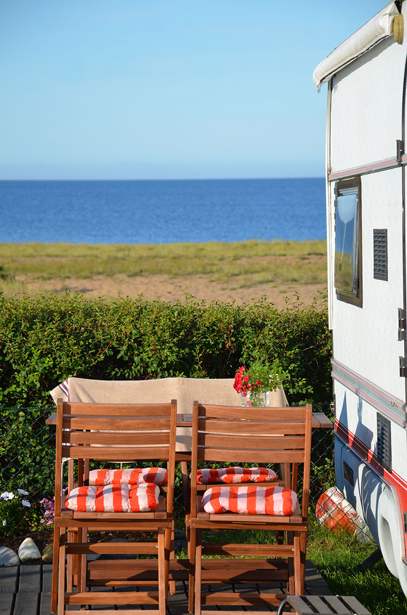 Fotografi på campingplats med havet i bakgrunden